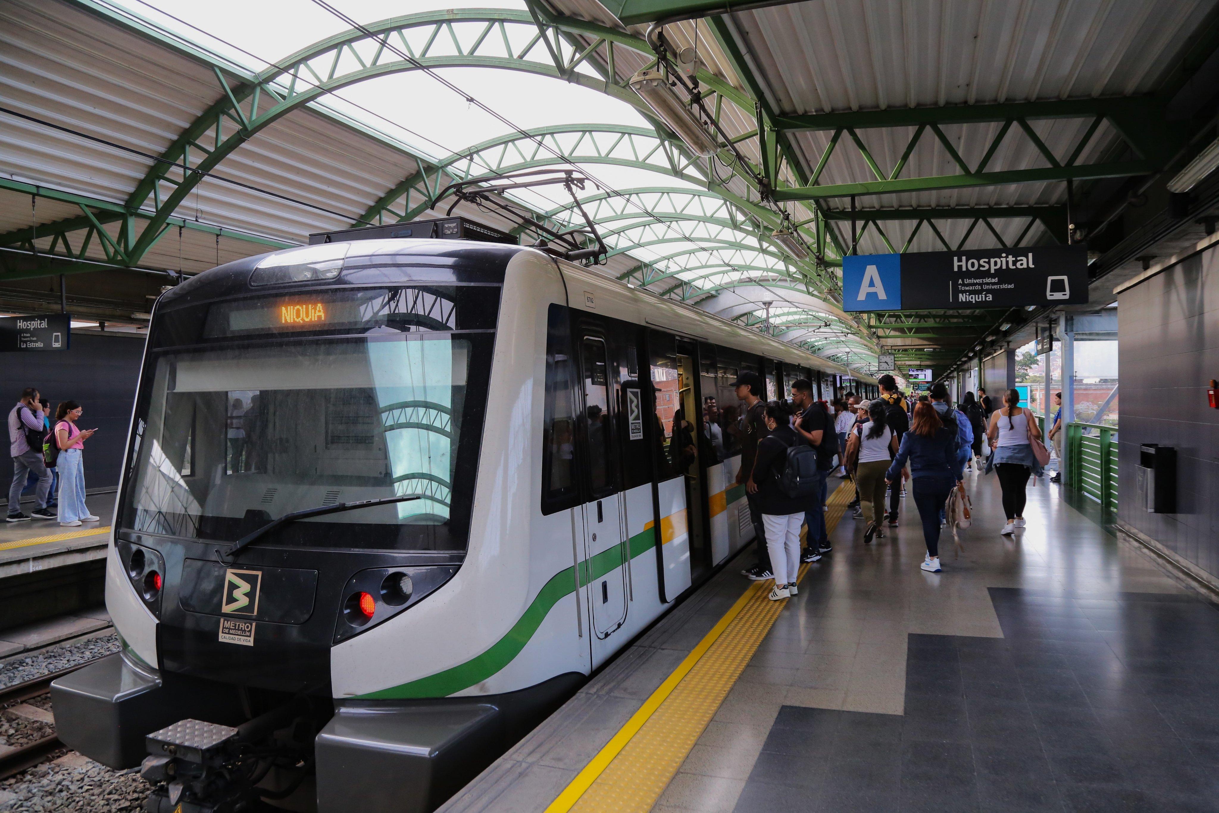 Estación Hospital del Metro de Medellín con tren de la Línea A y pasajeros, ubicada cerca de Prado Centro y de los apartamentos amoblados de Nook Cool Living