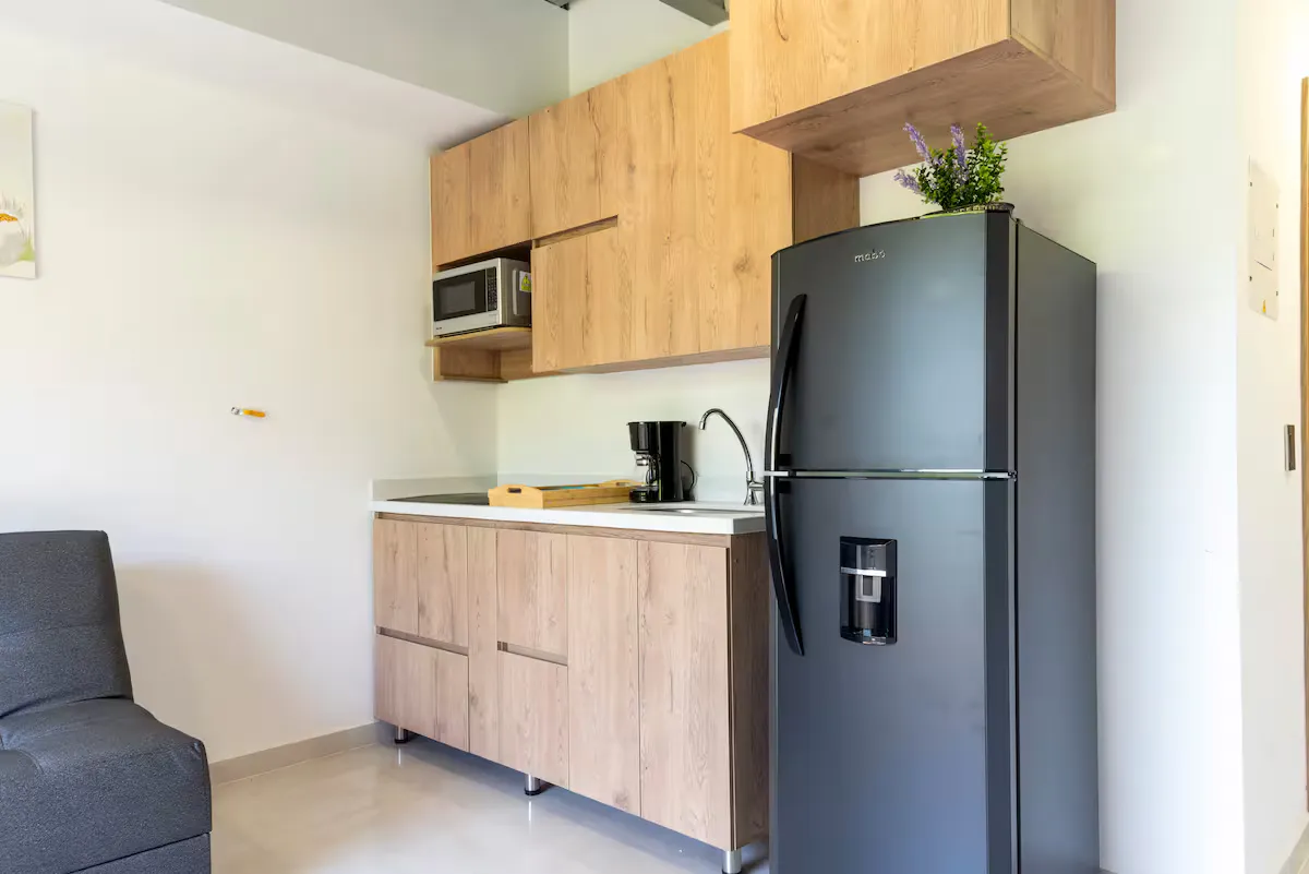 Cocina real de un loft de Nook Cool Living con electrodomésticos y almacenamiento visibles